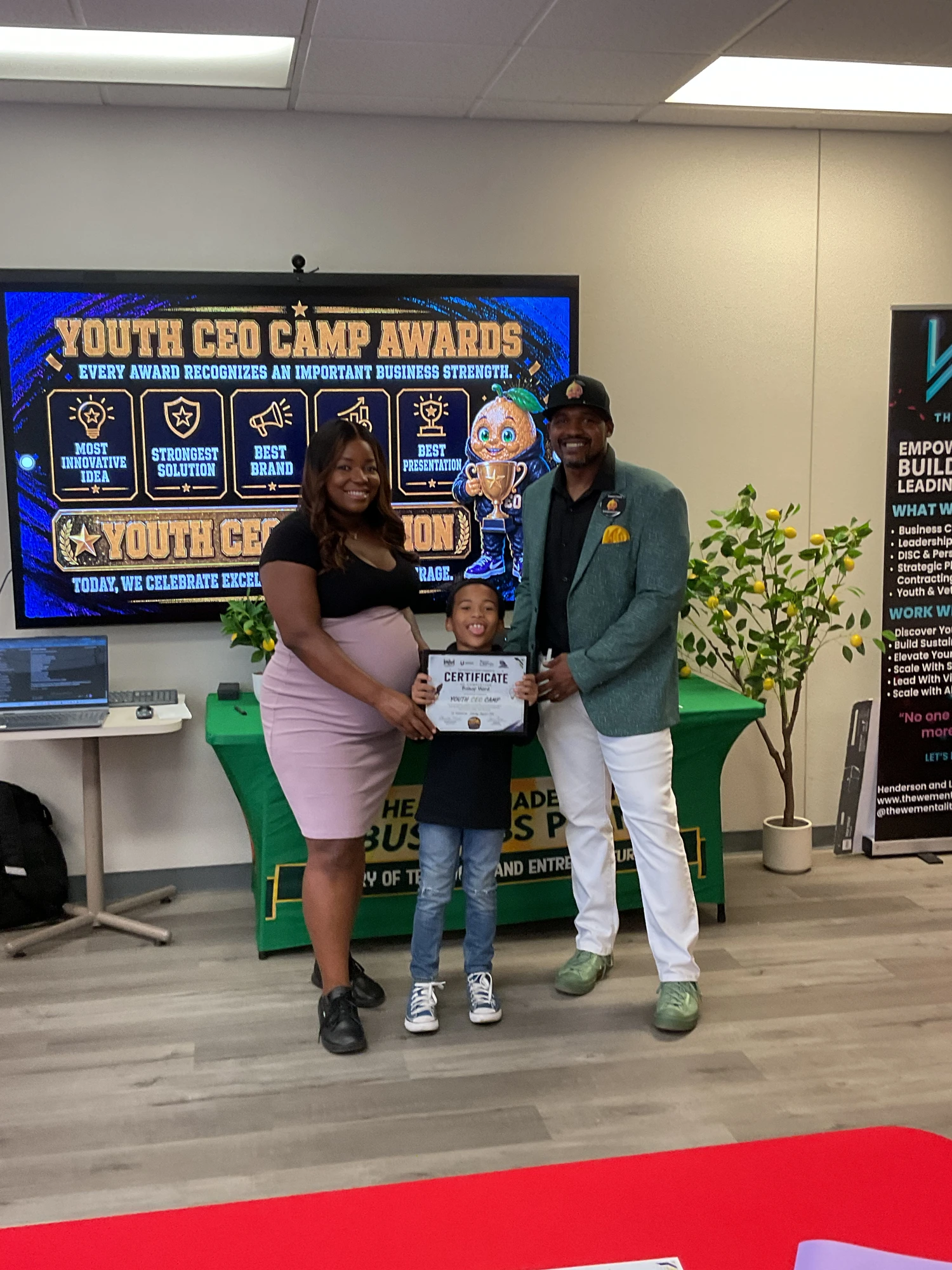 Marvin Williams receiving his Youth CEO Camp certificate with coaches