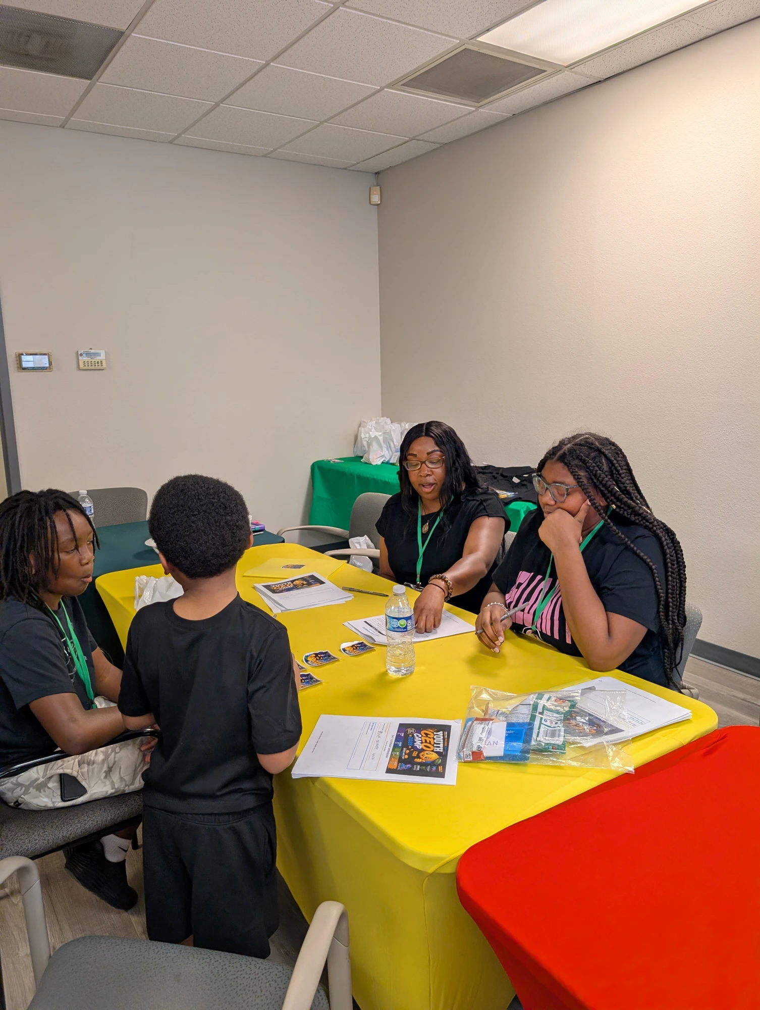 One-on-one mentorship huddle — coaches guiding a young CEO through his business plan worksheet