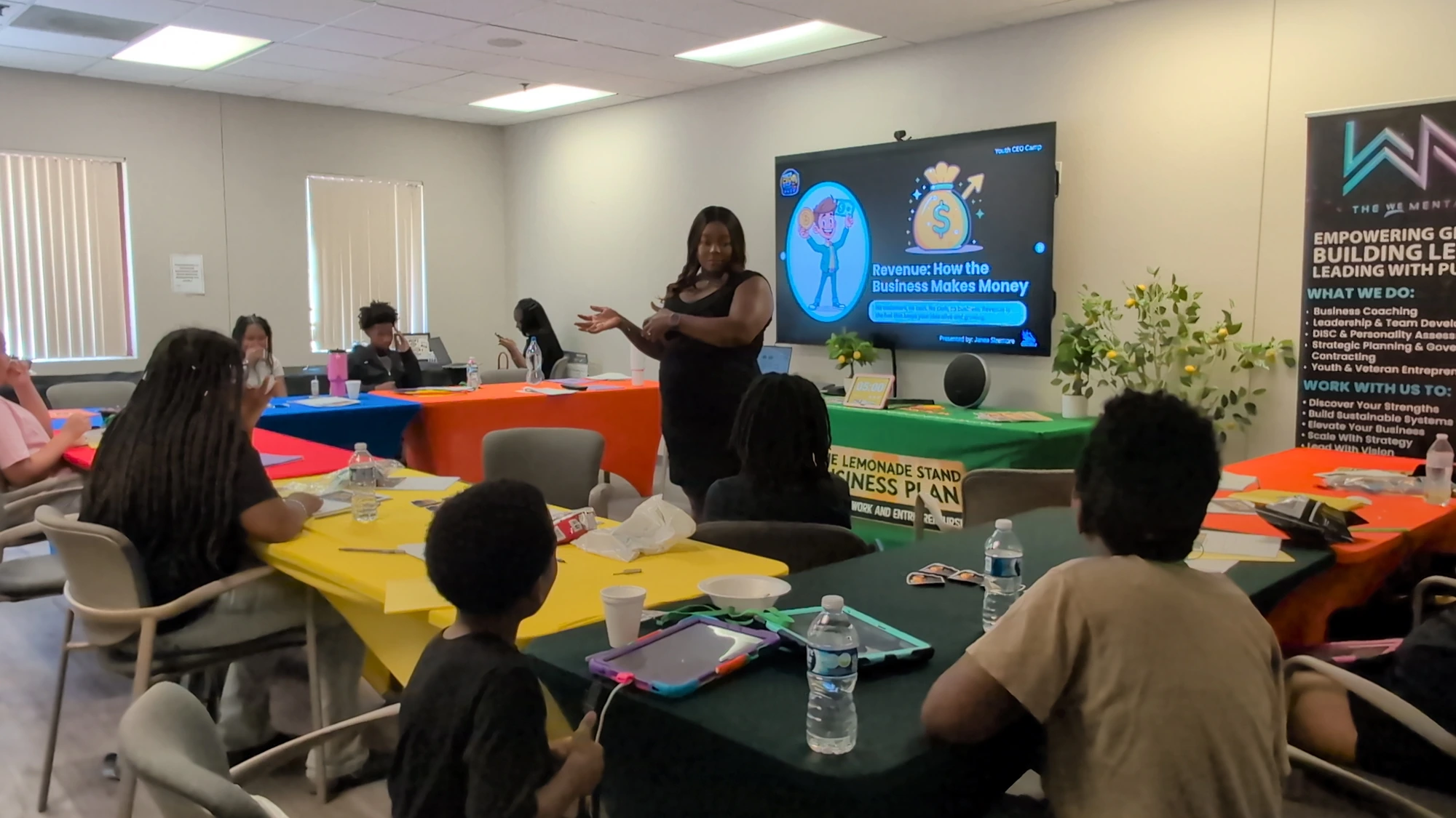 Coach teaching 'Revenue: How the Business Makes Money' during a Youth CEO Camp curriculum session